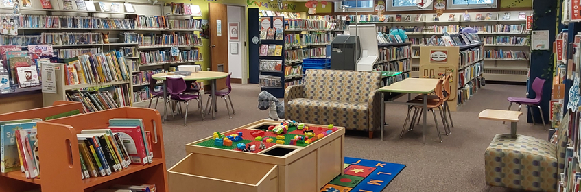 photo of children's floor showing book shelves, seating and the play area